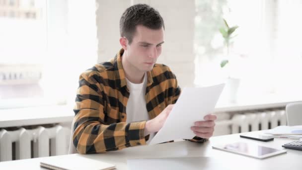 Pensivo Casual Jovem Leitura Documentos — Vídeo de Stock