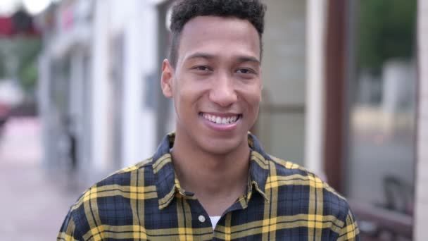 Buiten portret van lachende jonge Afrikaanse man — Stockvideo