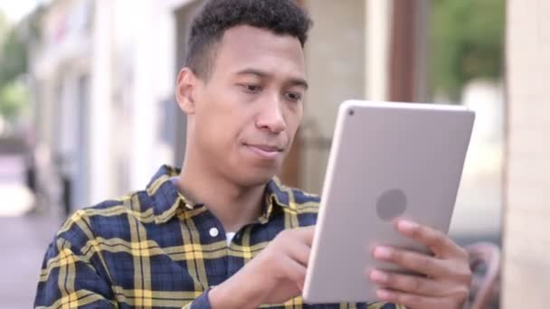 Jeune homme africain utilisant une tablette extérieure — Video