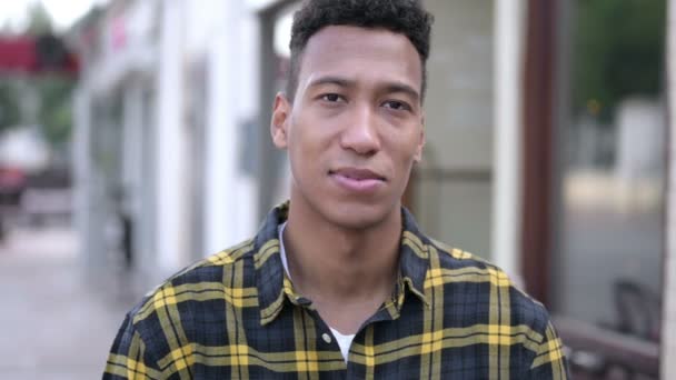 Tecken på seger av unga afrikanska mannen stående utomhus — Stockvideo