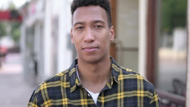 Utomhus, ung afrikansk man bjuder in nya människor — Stockvideo