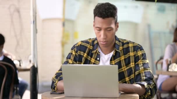 Ung afrikansk man arbetar på laptop, Utomhus Café — Stockvideo