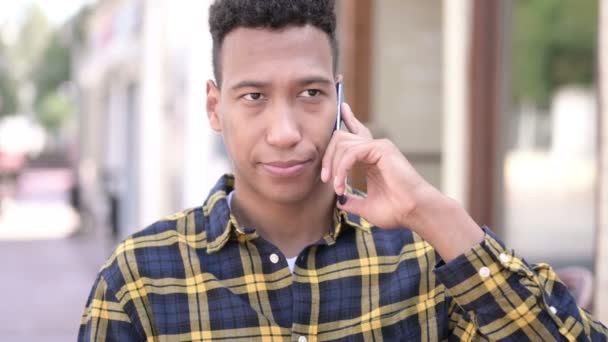 Υπαίθριος νέος Αφρικανός άνθρωπος μιλάει στο τηλέφωνο — Αρχείο Βίντεο