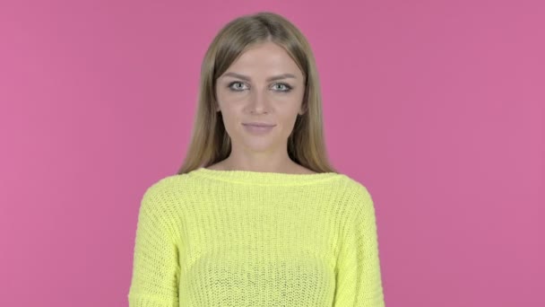 Feliz niña guiñando el ojo y sonriendo, fondo rosa — Vídeo de stock