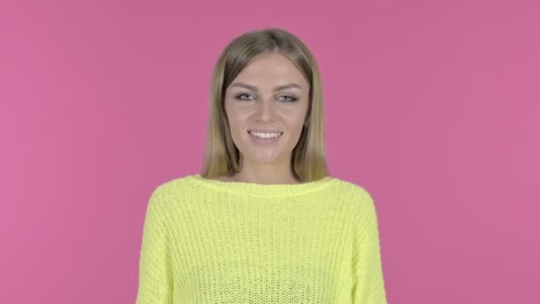 Upphetsad ung flicka som visar tummen upp, rosa bakgrund — Stockvideo