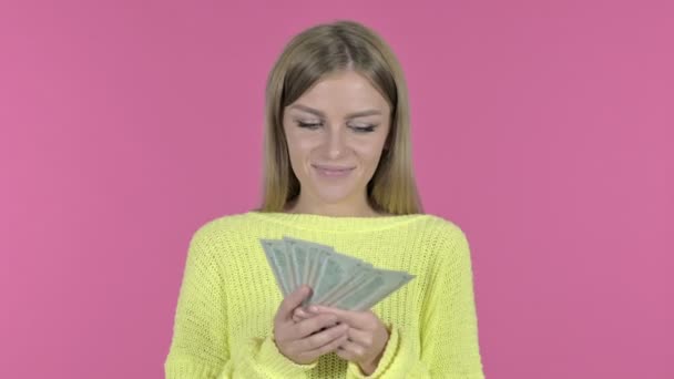 Boldog fiatal lány gazdaság pénz és mosolygó, Pink háttér — Stock videók