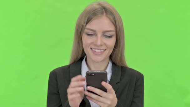 Jonge zakenvrouw met behulp van smartphone tegen Chroma Key — Stockvideo