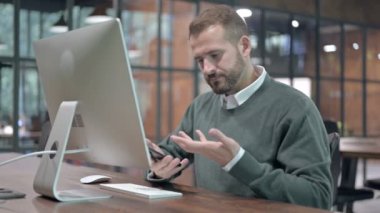 Öfkeli Adam Bilgisayar üzerinde çalışırken cep telefonundan çağrı aldı