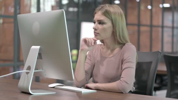 Junge Frau denkt während der Arbeit am Computer — Stockvideo