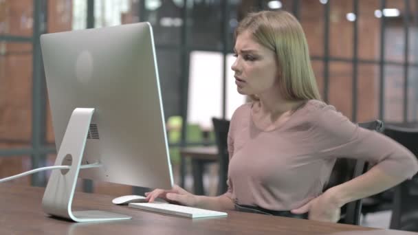 コンピューターを使いながら背中を痛めている疲れた女 — ストック動画