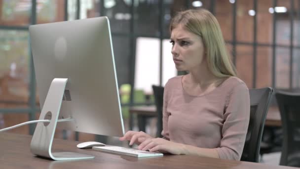 Fokussierte Frau regt sich bei der Arbeit am Computer auf — Stockvideo