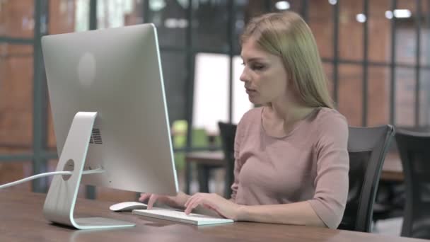 컴퓨터 작업을 하는 동안 엄지손가락을 들고 있는 쾌활 한 여성 — 비디오
