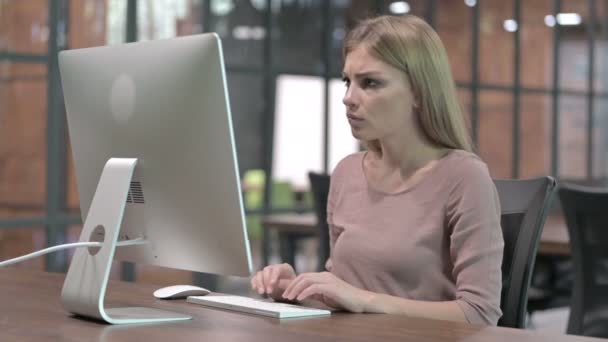 Jonge vrouw tonen duimen naar beneden tijdens het werken op de computer — Stockvideo