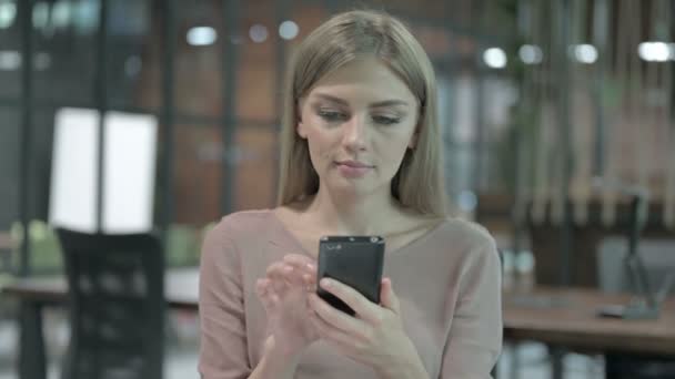 Портрет женщины, празднующей успех на мобильном телефоне — стоковое видео