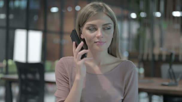 휴대폰으로 얘기하는 젊은 여성의 사진 — 비디오