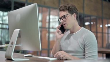 Üzgün genç adam konuşuyor ve cep telefonunda bağırıyor.