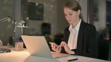 Genç İş Kadını Gece Ofisinde Cep Telefonu Kaydırıyor