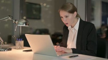 İş kadını geceleri dizüstü bilgisayarda çalışırken hayal kırıklığına uğruyor