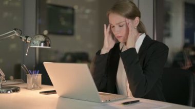 İş kadını geceleri dizüstü bilgisayarla uğraşırken baş ağrısı çekiyor