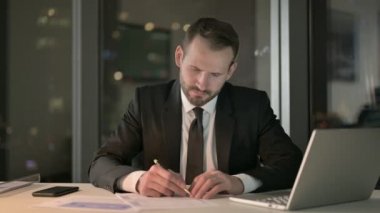 Akıllı İşadamı çalışıyor ve Büro Masasını Gece Bırakıyor