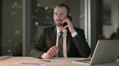 Hırslı İşadamı Ofiste cep telefonuyla konuşuyor.