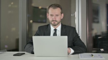 Ambitious Businessman Thinking and working on Laptop at Night