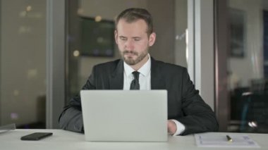 Handsome Businessman working on Laptop at Night