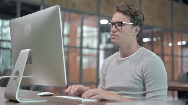 Fáradt fickó, akinek nyaki fájdalma van, miközben az Asztalon dolgozik — Stock videók