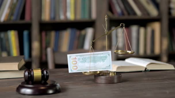 금으로 입힌 황동 저울 과 나무로 된 법정 실위에 놓인 돈 — 비디오