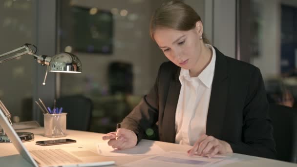 Ambitieuze zakenvrouw die 's nachts documenten schrijft — Stockvideo