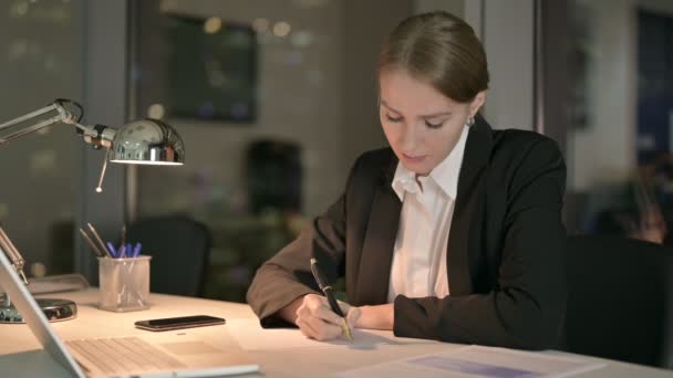 Focused Businesswoman Pensare e scrivere sul documento di notte — Video Stock