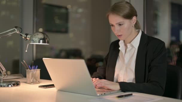 Müde Geschäftsfrau mit Rückenschmerzen nachts im Büro — Stockvideo