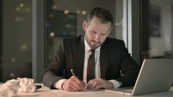 Амбициозный бизнесмен, пытающийся написать документ ночью — стоковое видео