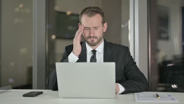 Стрессовый бизнесмен, страдающий головной болью в офисе ночью — стоковое видео