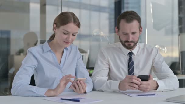 Представители бизнеса, пользующиеся мобильным телефоном на офисном столе — стоковое видео