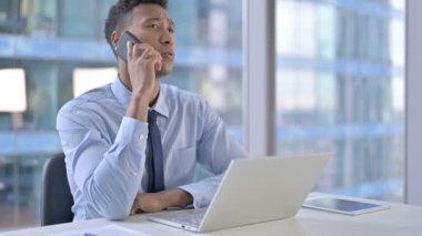 Ofiste Afrikalı Amerikalı İşadamı Cep telefonuyla konuşuyor