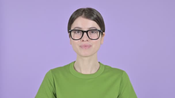 Junge Frau winkt vor rosa Hintergrund in die Kamera — Stockvideo