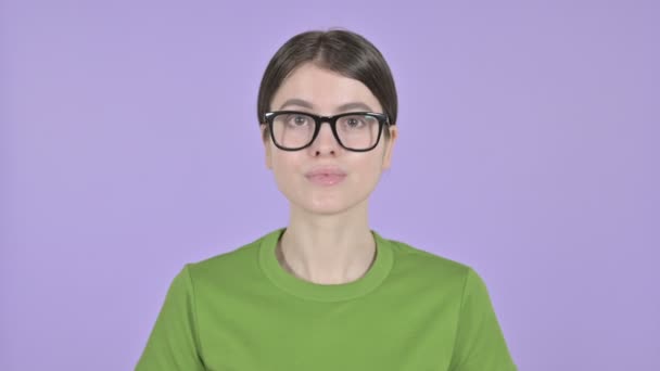 Ernste junge Frau zeigt mit dem Finger auf rosa Hintergrund — Stockvideo