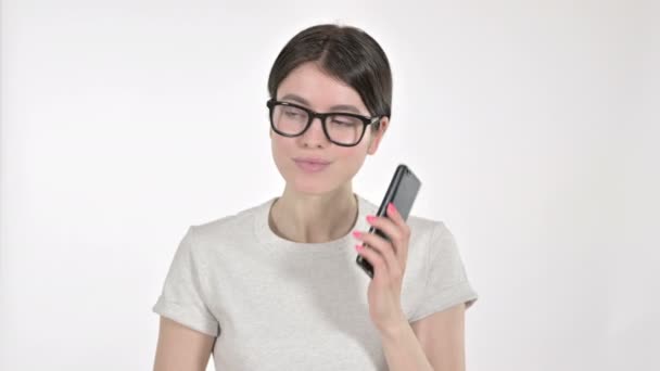 Ung kvinna tala i telefon på vit bakgrund — Stockvideo