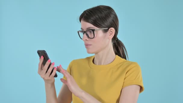 진지 한 젊은 여성 이 보라색 배경으로 핸드폰으로 인터넷 서핑을 하고 있다 — 비디오