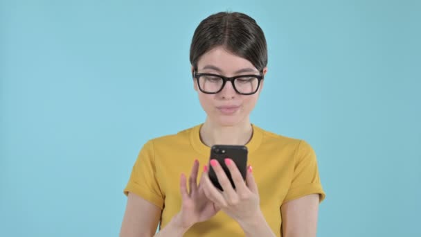 Mujer joven usando el teléfono móvil sobre fondo púrpura — Vídeos de Stock