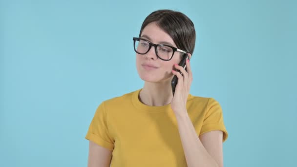 Щаслива молода жінка розмовляє по телефону на фіолетовому тлі — стокове відео