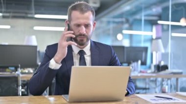 Sinirli Genç İş Adamı Akıllı Telefonla Konuşuyor