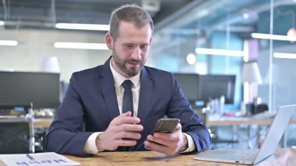 Úspěšný mladý podnikatel slaví na chytrém telefonu — Stock video