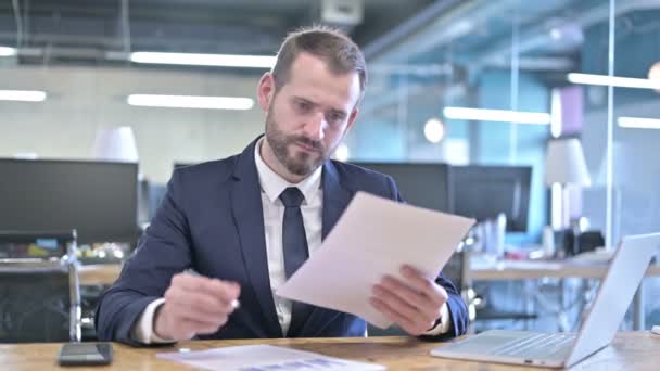 Красивий бізнесмен читає і робить документи — стокове відео