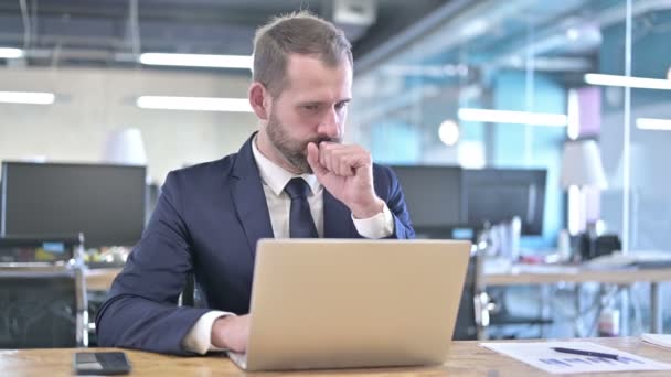 Ung affärsman som har hosta medan du arbetar på laptop — Stockvideo