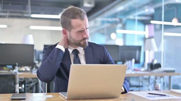 Cansado jovem empresário com dor no pescoço no escritório — Vídeo de Stock