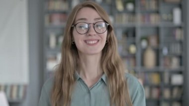 Ofiste gülümseyen ve alkışlayan genç kadın portresi