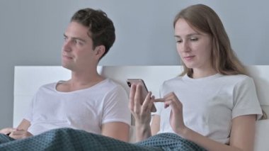 O Smartphone kullanırken, Hayal kırıklığına uğramış Adam Çiftle Oturuyor