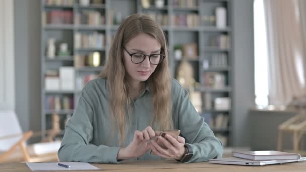 Jovem mulher bem sucedida comemorando ao usar Smartphone — Vídeo de Stock